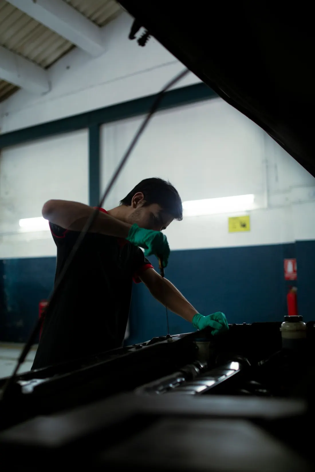 Automotive technician checking a vehicle engine